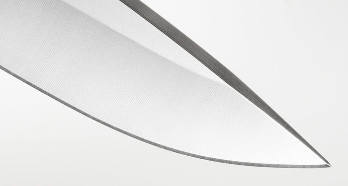 Close-up image of the finely honed blade tip of a Leatherman knife, highlighting the precise edge geometry and clean grind lines for exceptional sharpness and cutting performance.