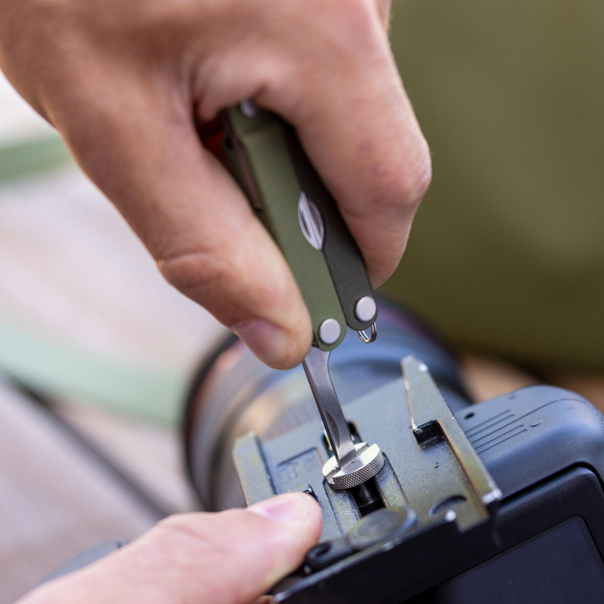 Translation missing: fr.A person using the medium screwdriver on a Spruce Leatherman Micra® to tighten a camera mount