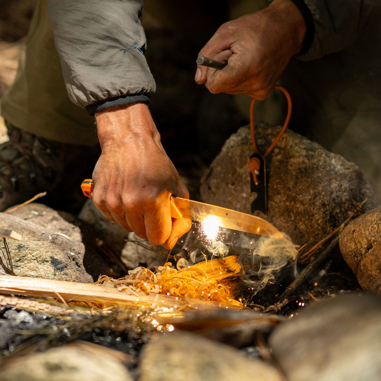 Translation missing: en.A person holds a Leatherman Orange pop Pioneer to a piece of wood, attempting to start a fire