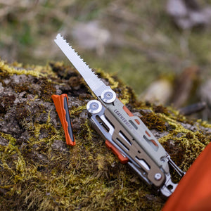 Translation missing: es.Tundrascape Leatherman Signal® laying on a mossy log, showcasing the ferro rod and saw