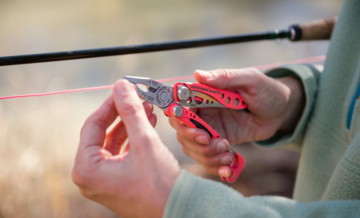 Translation missing: es.Person using a Guava Leatherman Skeletool® CX multitool pliers on a fishing line