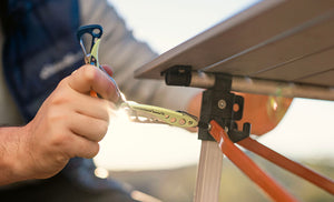 Translation missing: es.Person using a Verdant Leatherman Skeletool® CX multitool on an outdoor table