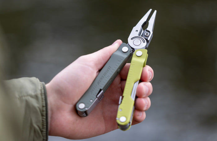 Translation missing: de.Person holding a Mossy Slate Leatherman Rebar® multi-tool with pliers, showcasing its versatility and design